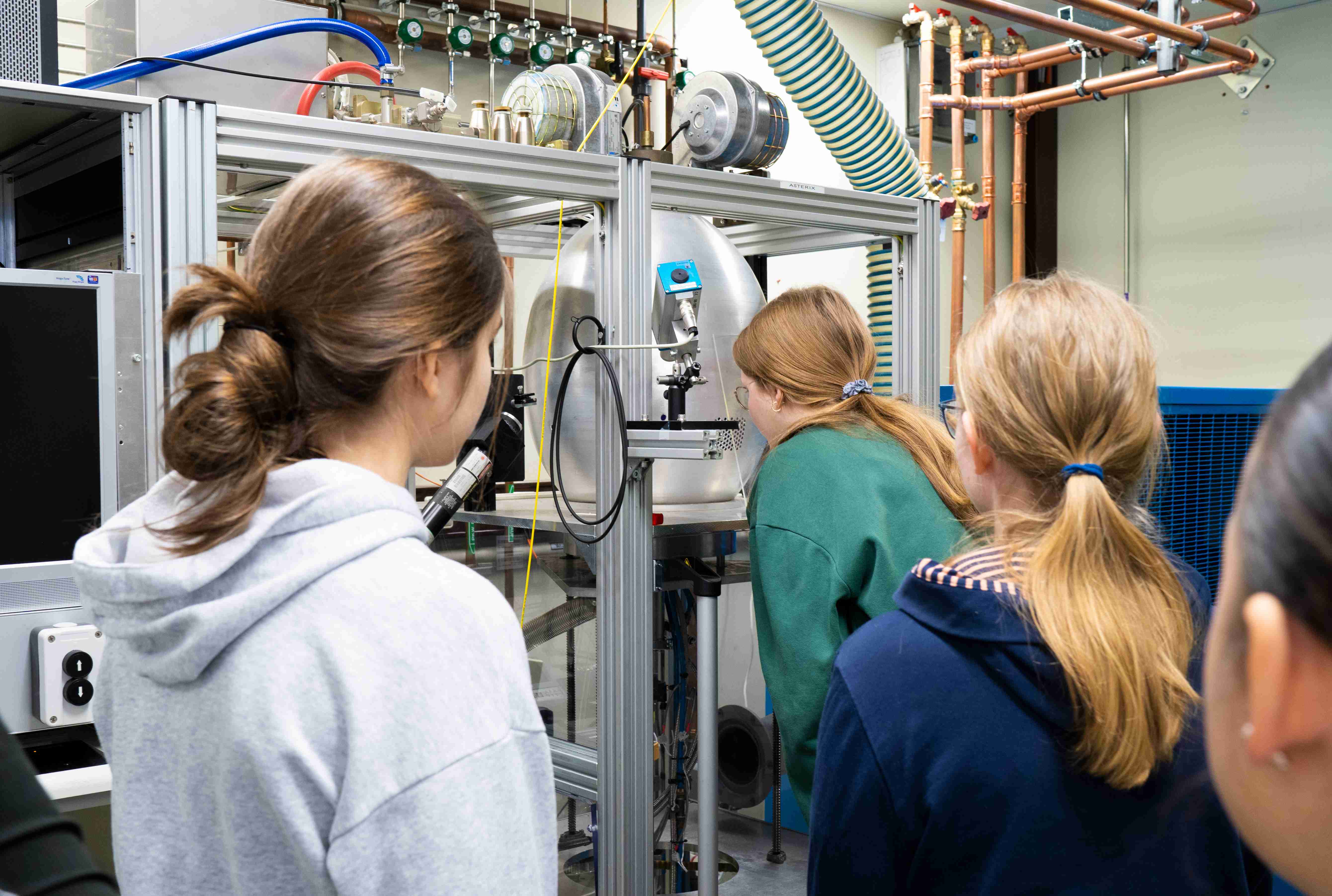Im Labor schauen Mädchen in einen Diamantreaktor.