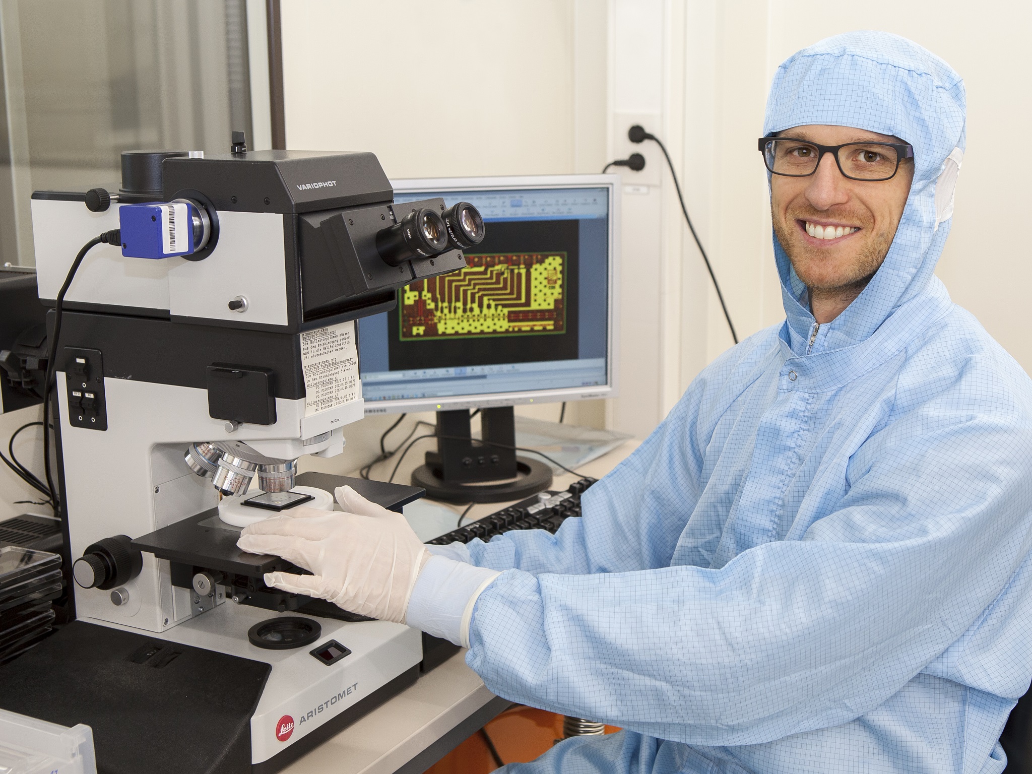 Markus Rösch sitzt an einem Mikroskop am Fraunhofer IAF