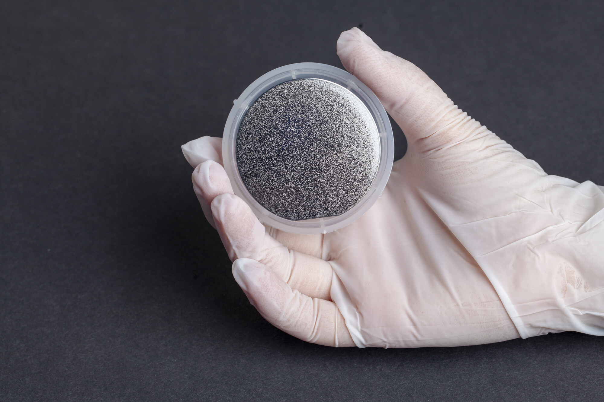 Hand in glove holding a diamond wafer