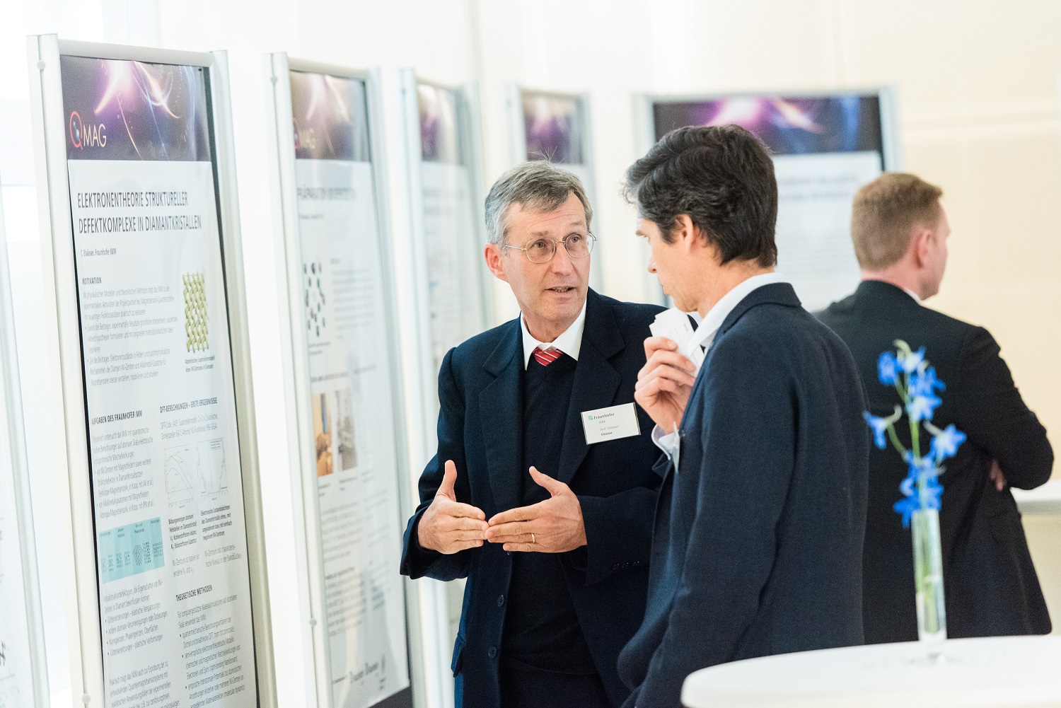 two men discuss during a poster presentation
