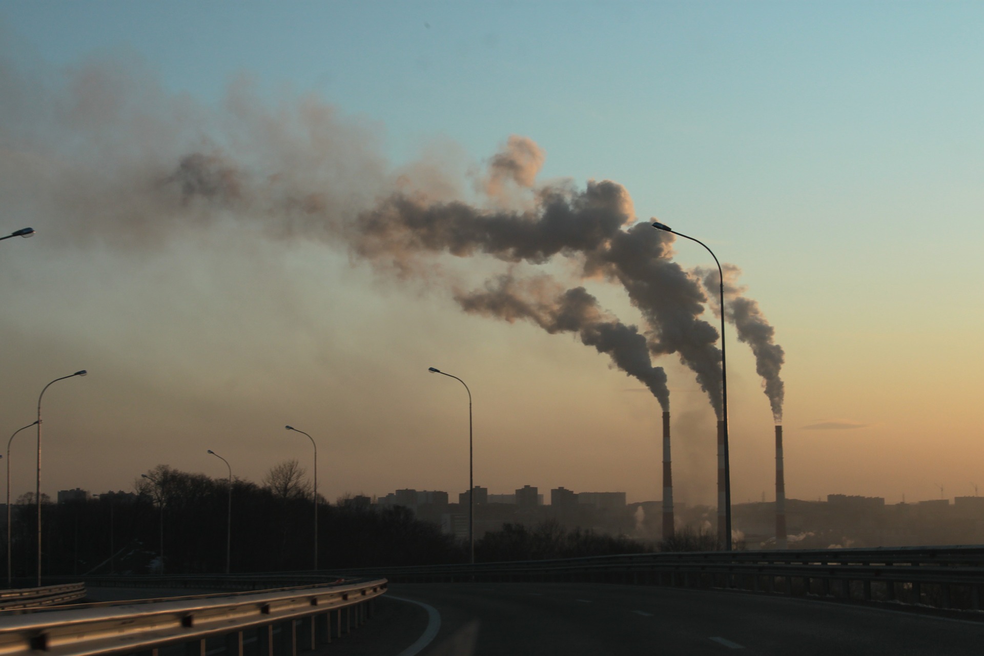 View from a motorway at smoking factory chimneys.