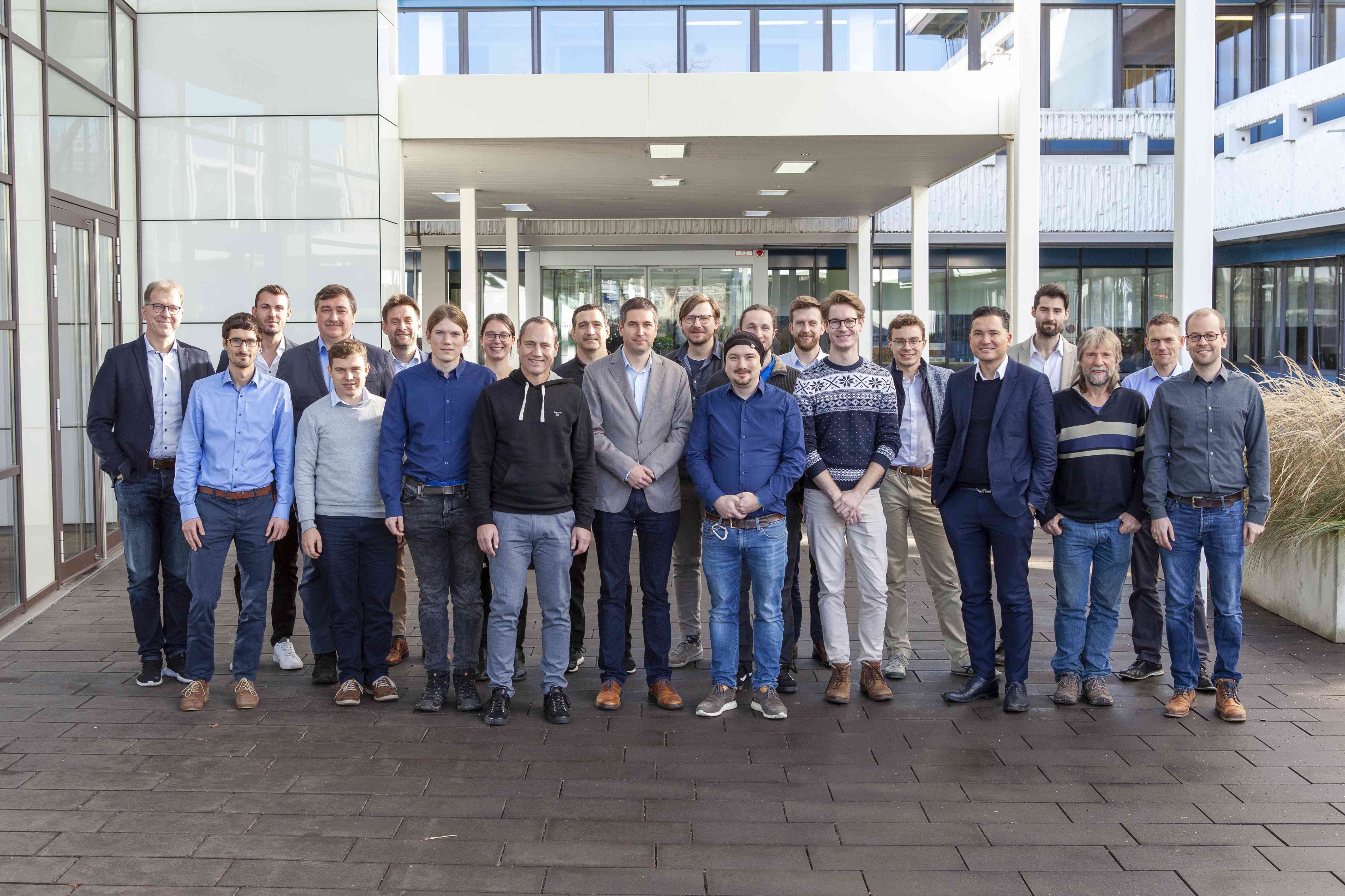 The project participants pose for the group picture in front of the main building of Fraunhofer IAF.